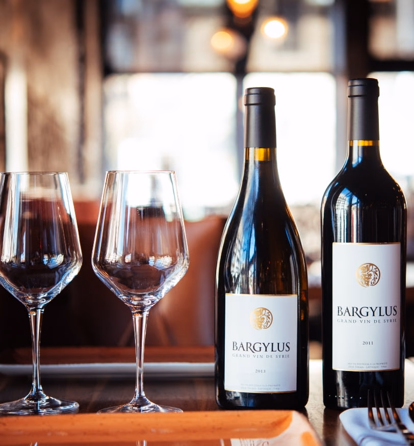 Bouteilles de Bargylus, vin syrien, sur une table dressée.